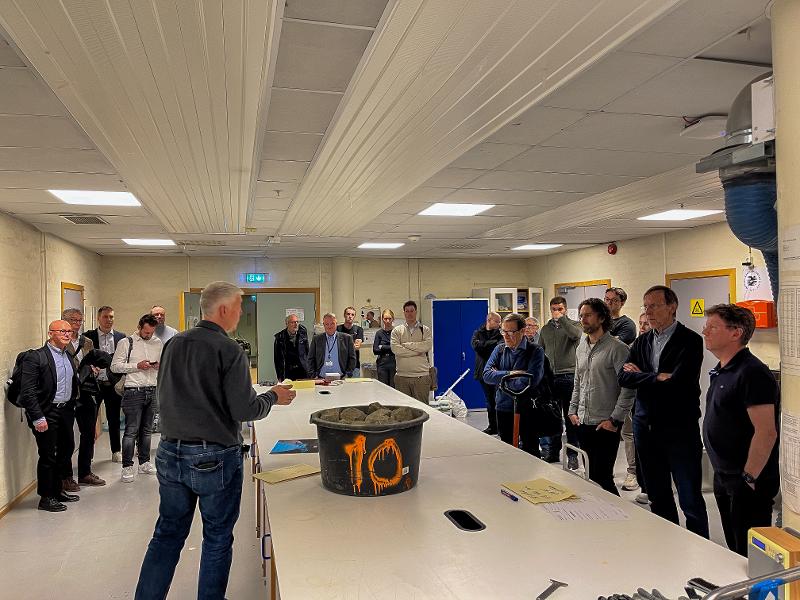 En mann forklarer en gruppe mennesker ting på et laboratorium